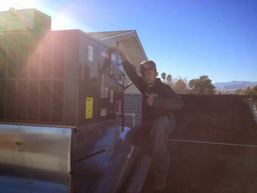 HVAC technician performing Heat Pump Repair on a rooftop unit in Canyon